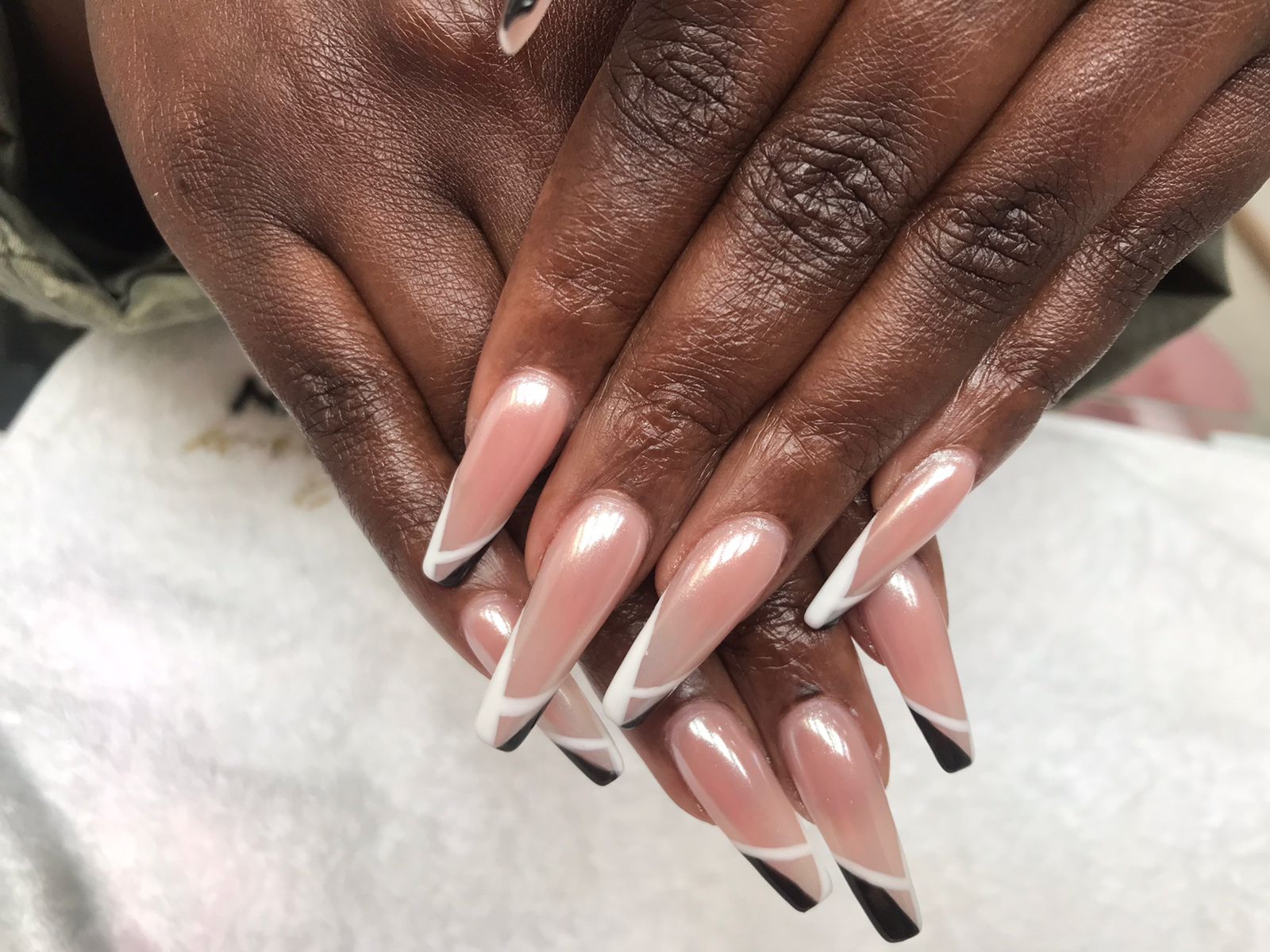 Long nude chrome nails with black and white angled French tips by Laira Touch
