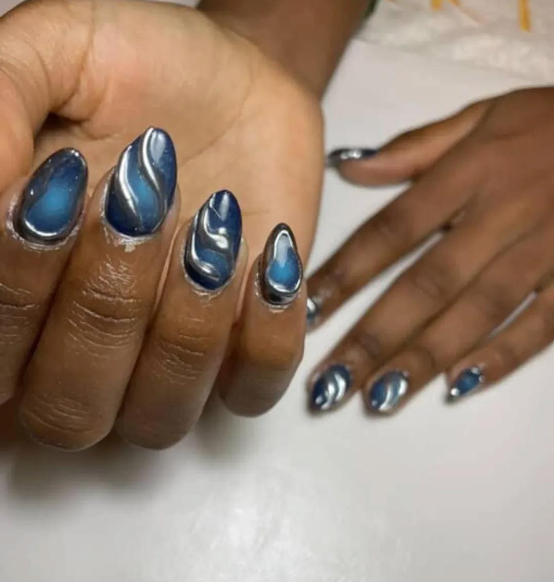Blue almond nails with silver chrome swirl art by Eilish Bratz