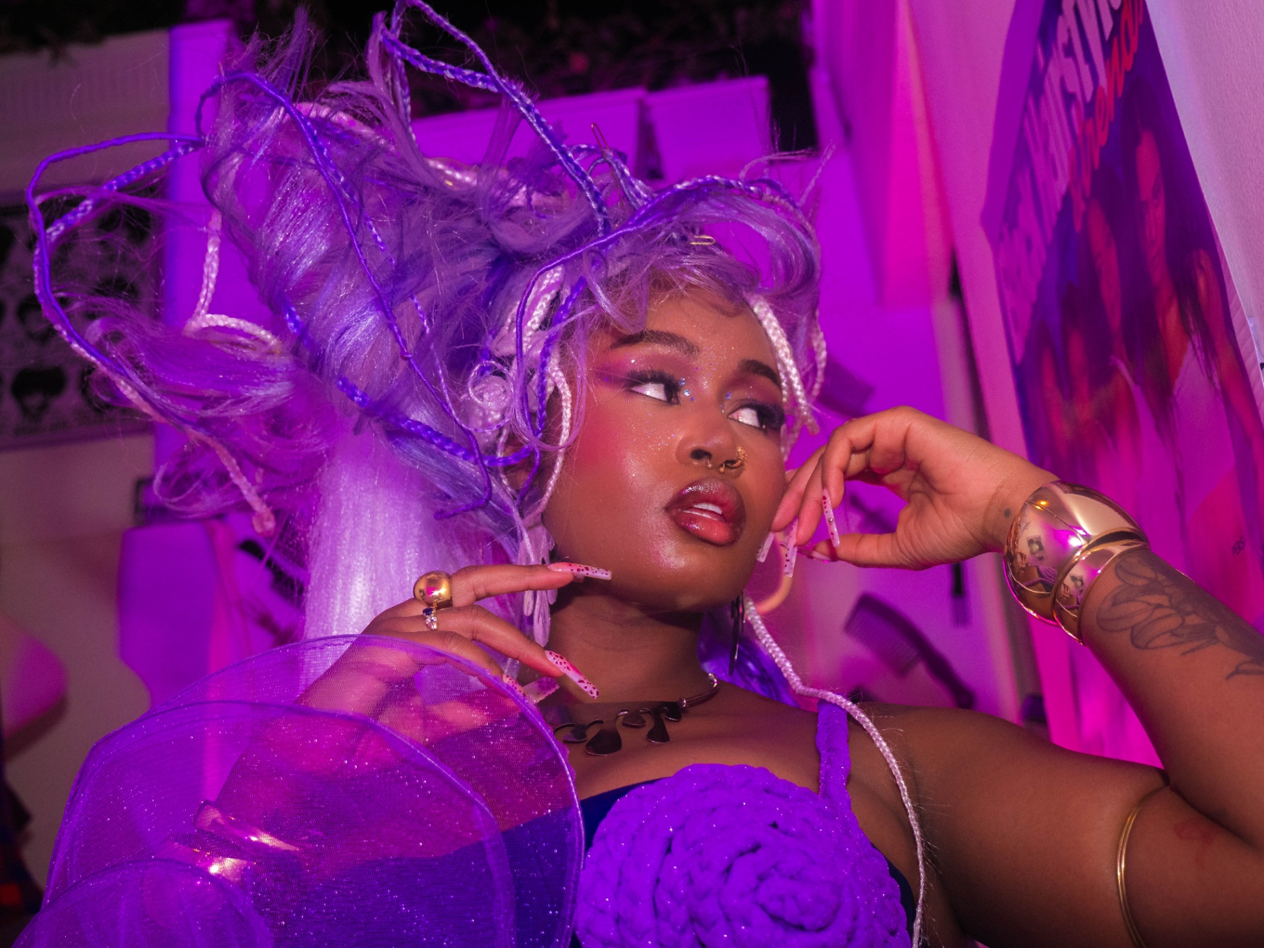 Model with sculptural purple braids under neon lighting