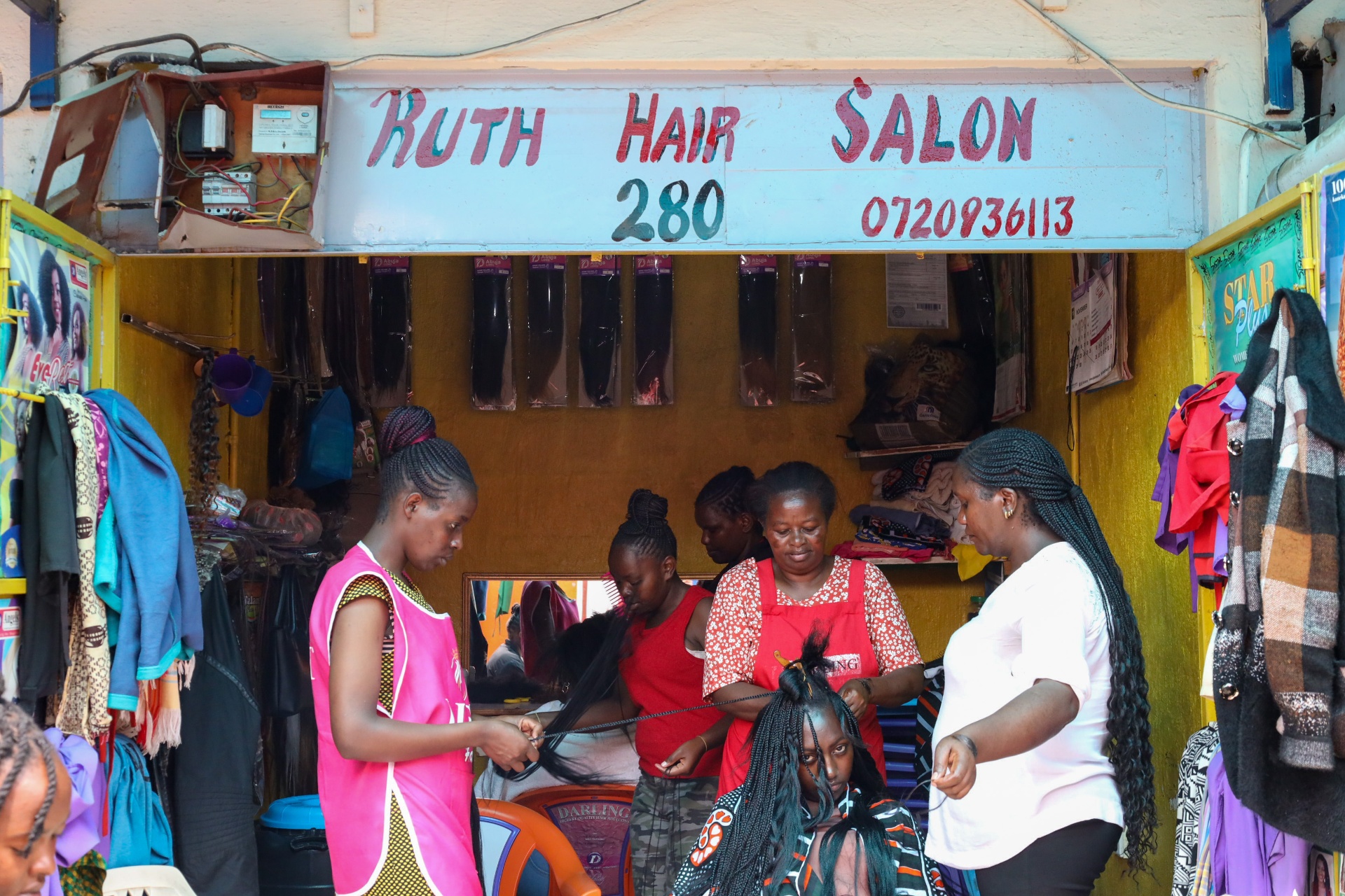 Ruth Hair Salon storefront with braiders working on a client